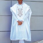 Man wearing white with a crossed leg photo shoot